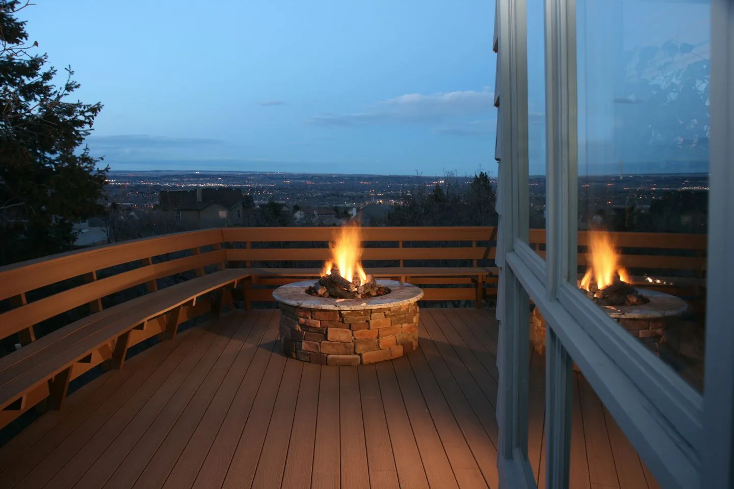 A fire pit on a wooden deck at dusk, with city lights twinkling in the background, creates the perfect urban retreat. Fire pits not only provide warmth but also transform any space into an inviting oasis.